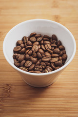 Cup of Coffee Beans roasted on a wooden table with fresh bean with great aroma