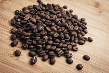 Coffee beans roasted on a wooden table with much of beans with a great aroma