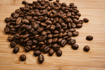 Coffee beans roasted on a wooden table with much of beans with a great aroma