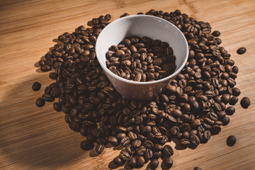 Cup of Coffee Beans roasted on a wooden table with fresh bean with great aroma