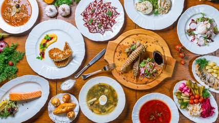 Assorted dishes borsch, sorrel soup, lamb kebab, Fried salmon, meat Solyanka, herring with potatoes