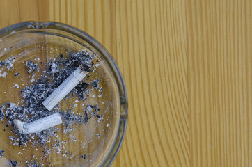 cigarette butts in an ashtray on a wooden background