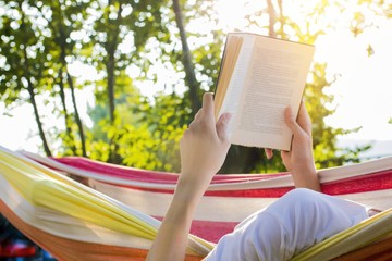 reading at dusk in the hammock with the open book