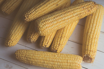 Corn yellow golden summer organic on wooden table closeup, top view, on day sun light.