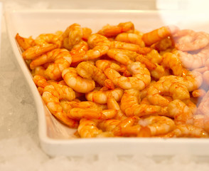 Peeled shrimps in a plate on ice