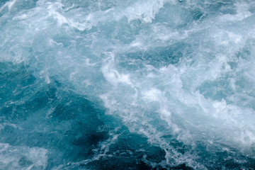 Naklejka na ściany i meble Wave in troubled blue sea water with white foam, abstract nature background concept