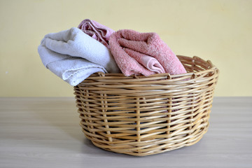 Wicker basket with towels on a light background