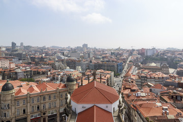 Fototapeta na wymiar Porto, Portugal – May 20, 2018. Scenic view of the town from the tower Clérigos Church. Orange roofs of the houses.