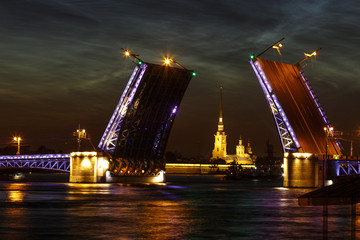 Obraz na płótnie Canvas Defocused city landscape of raised Palace bridge above river Neva. Colorful glare on the water.White night in Saint-Petersburg, Russia.