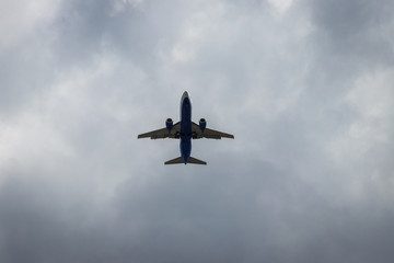 Fototapeta na wymiar background. defocus. airplane in blue sky with gray and white clouds