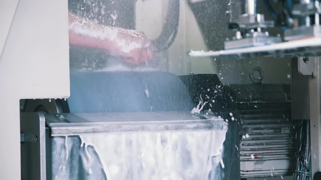 Worker maintaining stone grinding ski tuning machine