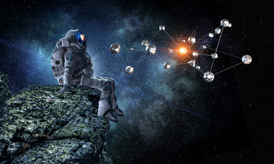 Fototapeta premium Spaceman on rock edge. Mixed media