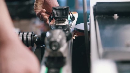 Edge grinder tuning skis in winter repair shop