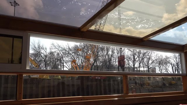 the motor ship passes along the river past the construction crane.