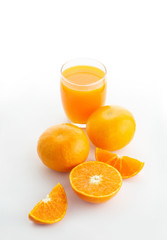 A glass of orange juice and an oranges isolated on white background 