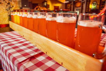 A very large tray with glasses of beer on the table.