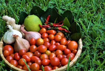 Vegetables in the bamboo basket is all from our own small vegetables garden, very fresh and healthy isolated on the green grass background after harvesting, summer in GA USA .      