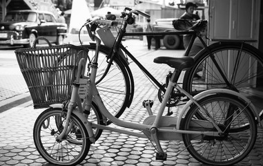 Close up Vintage two Bicycle on cobblestone street in the old town. Color in black and white.