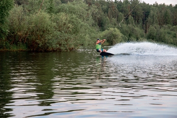 Fototapeta na wymiar Young man riding wakeboard on a lake