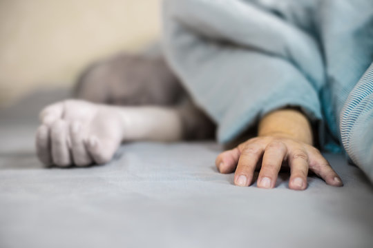 An Elderly Man Lies Asleep In A Bed
