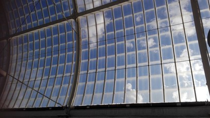 Obraz premium Blick in den blauen Himmel durch ein Dach eines großen Gewächshauses oder auch Tropenhaus