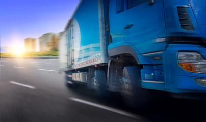 Blue truck driving fast on asphalt road in city close-up