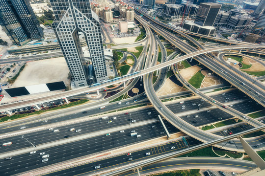 Aerial view of a big highway intersection in Dubai, UAE, at sunset. Transportation and communications concept.