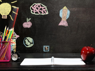 Accessories,pencils, books and apple on a black chalkboard,Back to School
