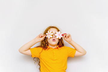 Surprised little girl with lollipop daisy on her eyes.