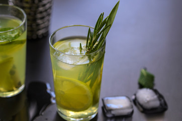 Mojito cocktail, lime, mint  and ice in glass decorated with herbs on dark background.  Copy space.Large image.
