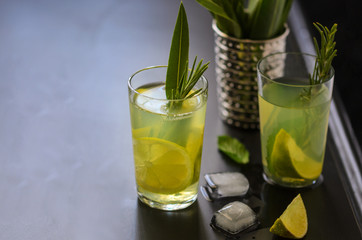 Mojito cocktail, lime, mint  and ice in glass decorated with herbs on dark background.  Copy space.Large image.