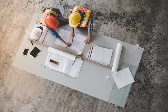 Top view of architects and engineers to help create a blueprint to build a modern building equipped with the skills to fix errors and make suggestions during construction.