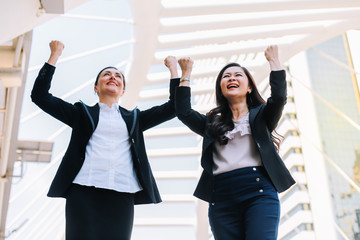 Businesswomen standing in the middle of the city.They is happy to succeed in his work.