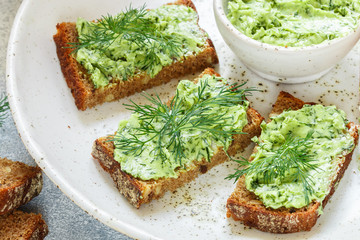 Delicious appetizer - butter with dill greens on rye bread with sunflower seeds