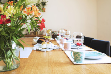 Close up of fresh and healthy summer breakfast in Mediterranean style kitchen.  Wooden table and a lot of flowers.