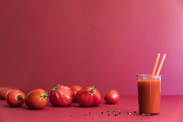 Fresh and summer tomato smoothies and tomato fruits and pepper on the red background. Many vitamins and minerals for healthy mind and body.