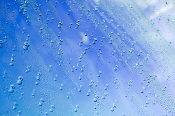 drops of water on the surface of a blue glass