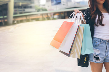 Young woman happy summer shopping with colorfull bags isolated on city background, copy space.
