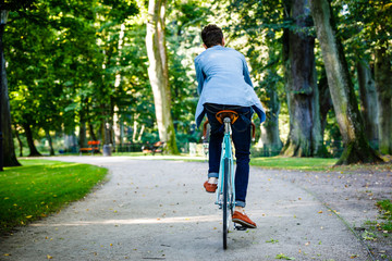 Young man biking in city park 