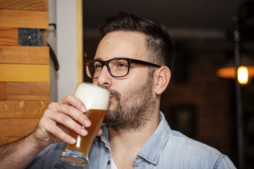 Guy drinking beer from glass in local pub