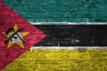 Flag of Mozambique over an old brick wall background, surface