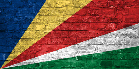 Flag of Seychelles over an old brick wall background, surface