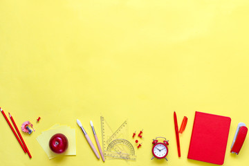 Yellow background and red school supplies. To go back to school. Flat view.