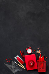 Black background and red school supplies. To go back to school. Flat view.