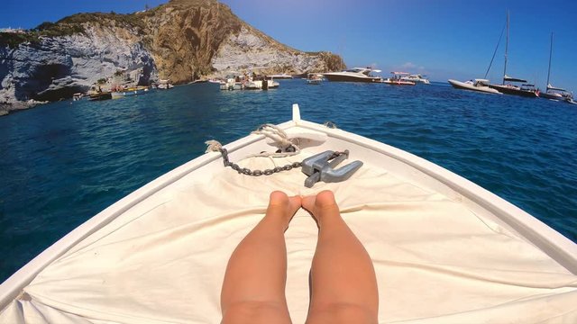 Woman legs and feet relaxing on a Boat Tanning while Sailing around Ponza island in italy