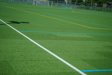 white lines and grean plastic grass on soccer or football field