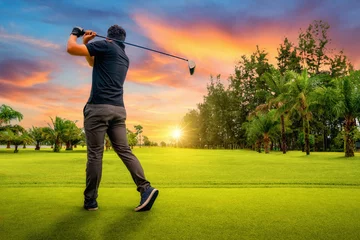 Tuinposter Golfer putting golf ball on the green golf, lens flare on sun set evening time, Golfer hitting golf shot with club on course while on summer vacation © sutthinon602