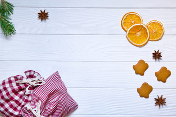 Christmas holidays conceptual background, dried oranges, ginger cookies, anise stars on white wooden background. Top view. Copy space, merry Christmas.
