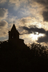 Church silhouette against a promise sun rising by clouds