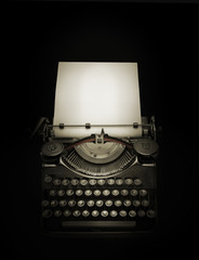 Ancient typewriter against black background in dark ambiance